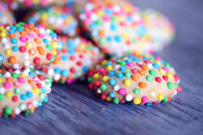 Freshly baked cookies with colorful sprinkles on a wooden table.