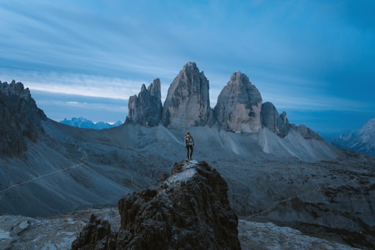 aerial photography of person standing on rock formation in Drei Zinnen Nature Park Italy