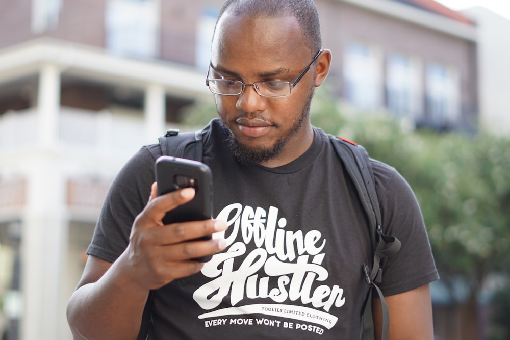 a man wearing glasses looking at his cell phone