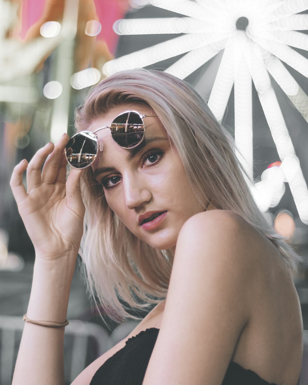 person wearing black strapless top holding her sunglasses