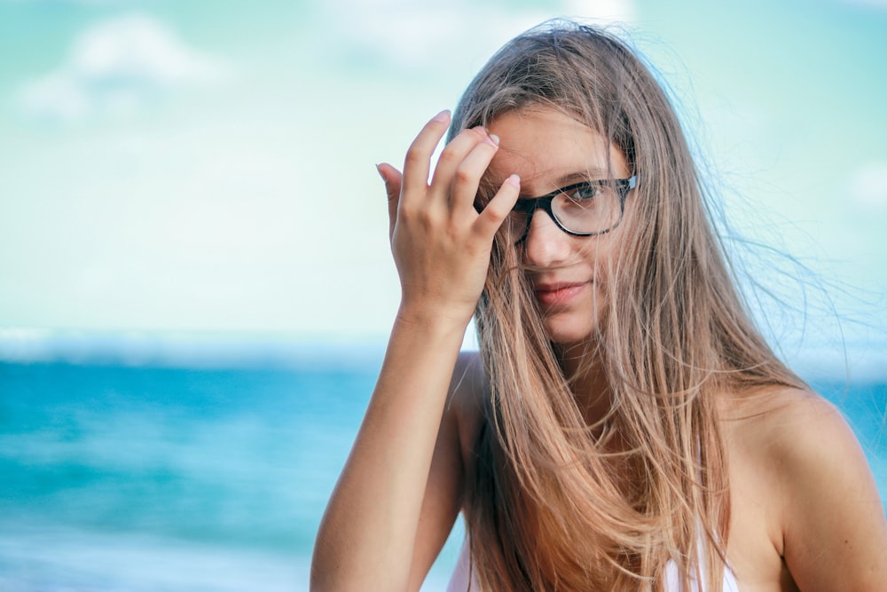 woman wearing black framed eyeglasses in white top