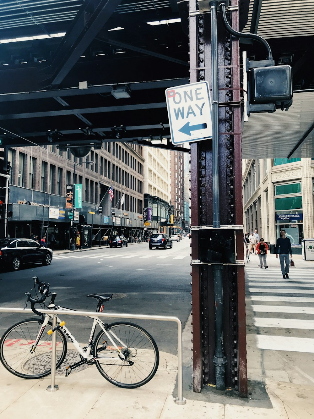 silver road bike under one way signage