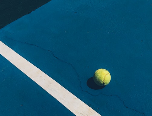 yellow tennis ball on court