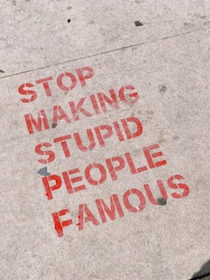 stop making stupid people famous signage