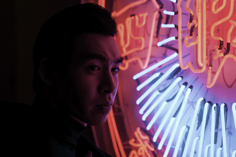 man standing near neon signage light