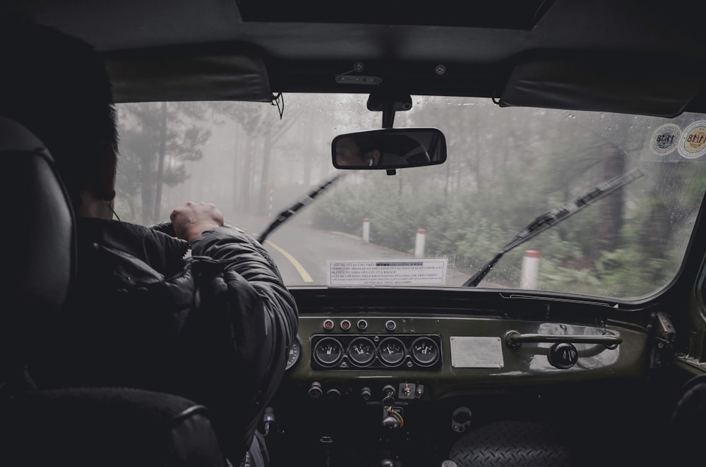 man driving car during rainy daytime