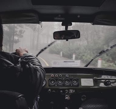 man driving car during rainy daytime