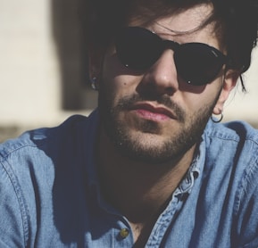 man wearing blue denim top and black sunglasses