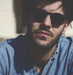 man wearing blue denim top and black sunglasses