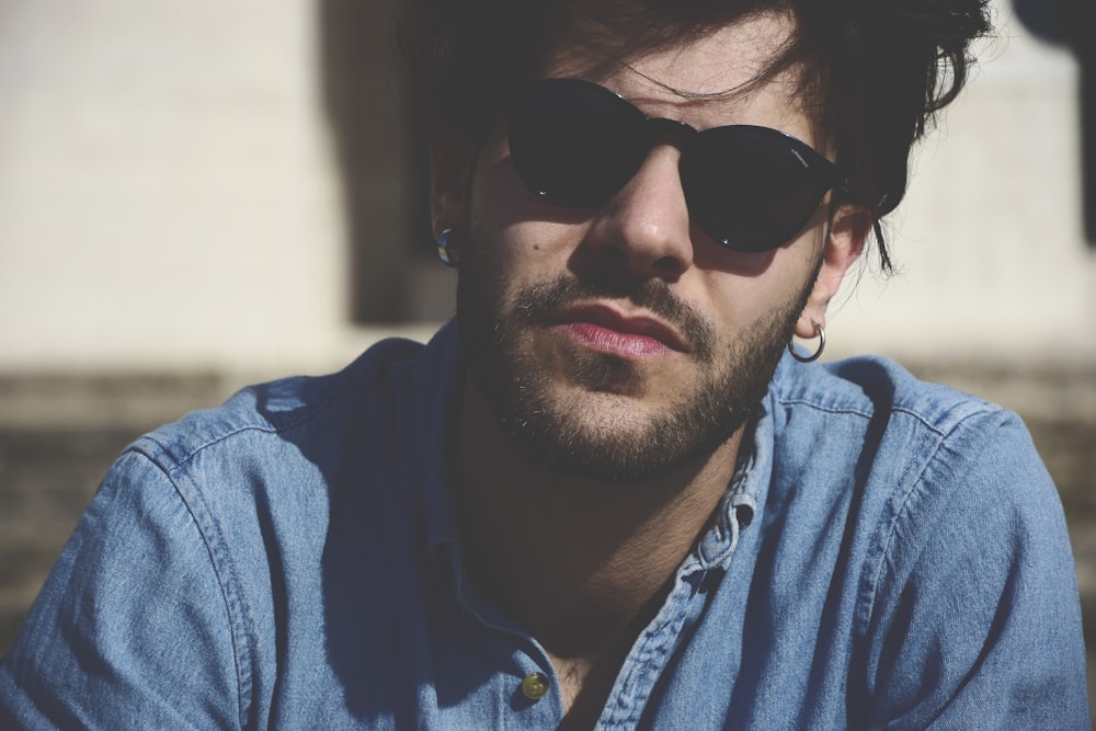 man wearing blue denim top and black sunglasses