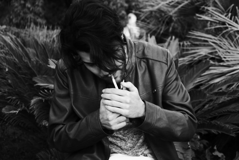 grayscale photo of man holding lighter