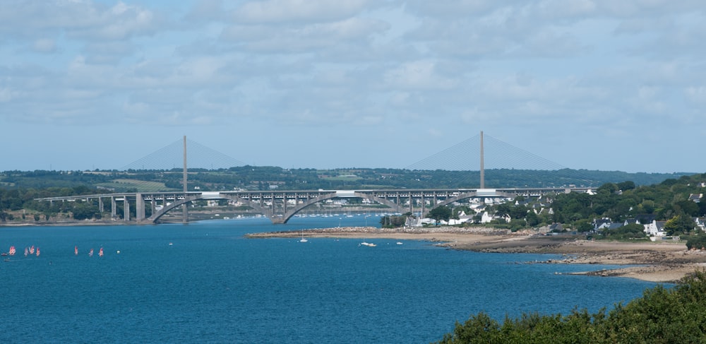 white and black bridge over blue sea under white sky during daytime