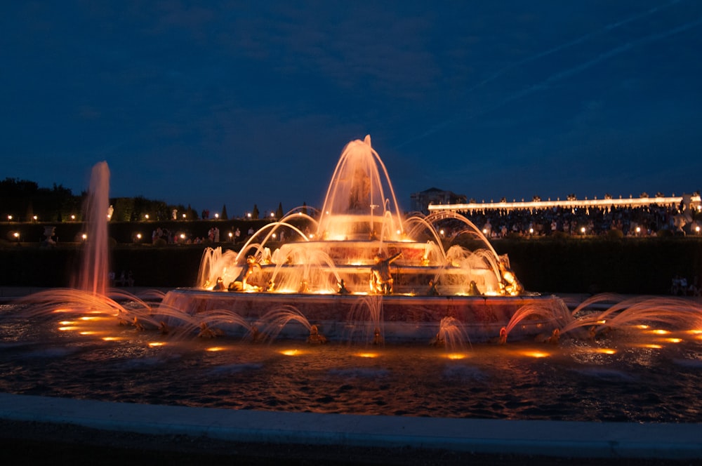 water fountain with lights turned on during night time