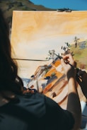 woman painting tree and cliff
