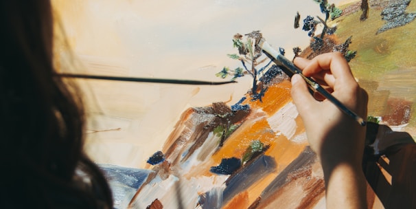 woman painting tree and cliff