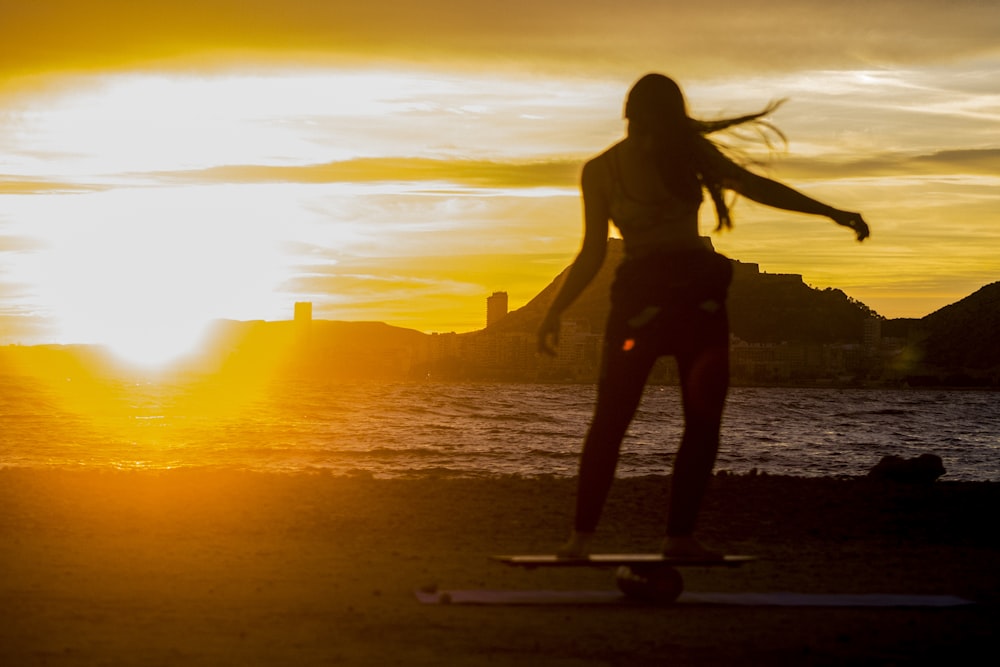 silhouette of woman standing at sunset