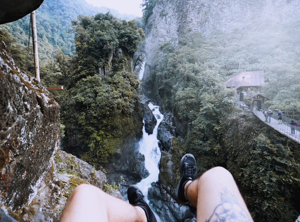 person sitting on peak of mountain