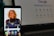 A smartphone displays a wallpaper featuring a blonde woman in a blue and red superhero costume. The device's screen shows various app icons such as WhatsApp, Instagram, Spotify, and Netflix. In the background, a laptop screen displays a Google search page.