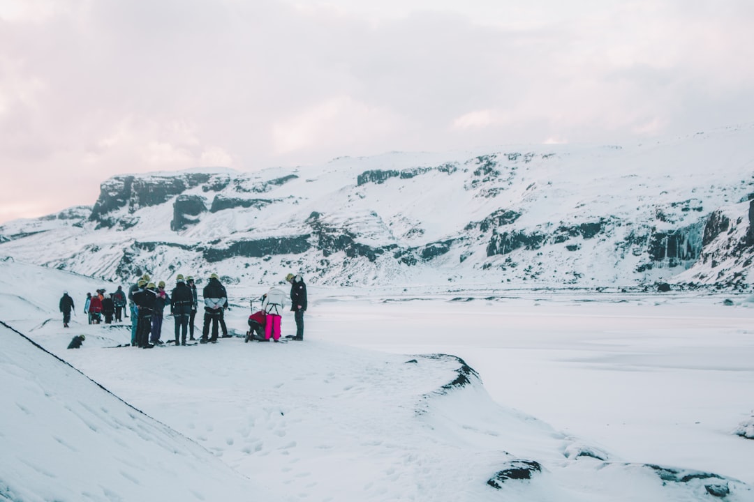 people gathering beside mountain covered by snow