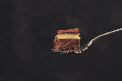 Close-up of kuih lapis layered dessert on a simple white plate with natural light highlighting its texture.