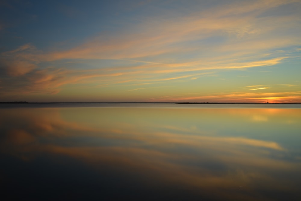 calm body of water during golden hour