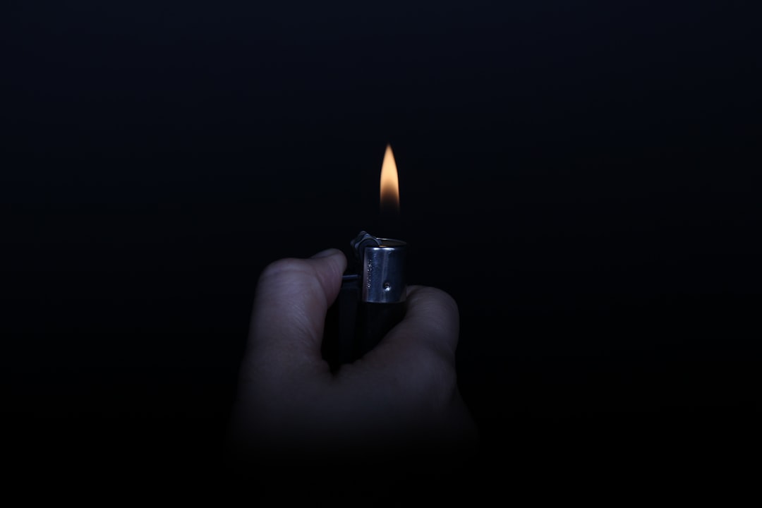 person holding lighted lighter