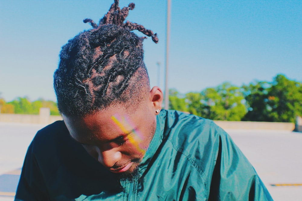 man in green jacket with braided hair