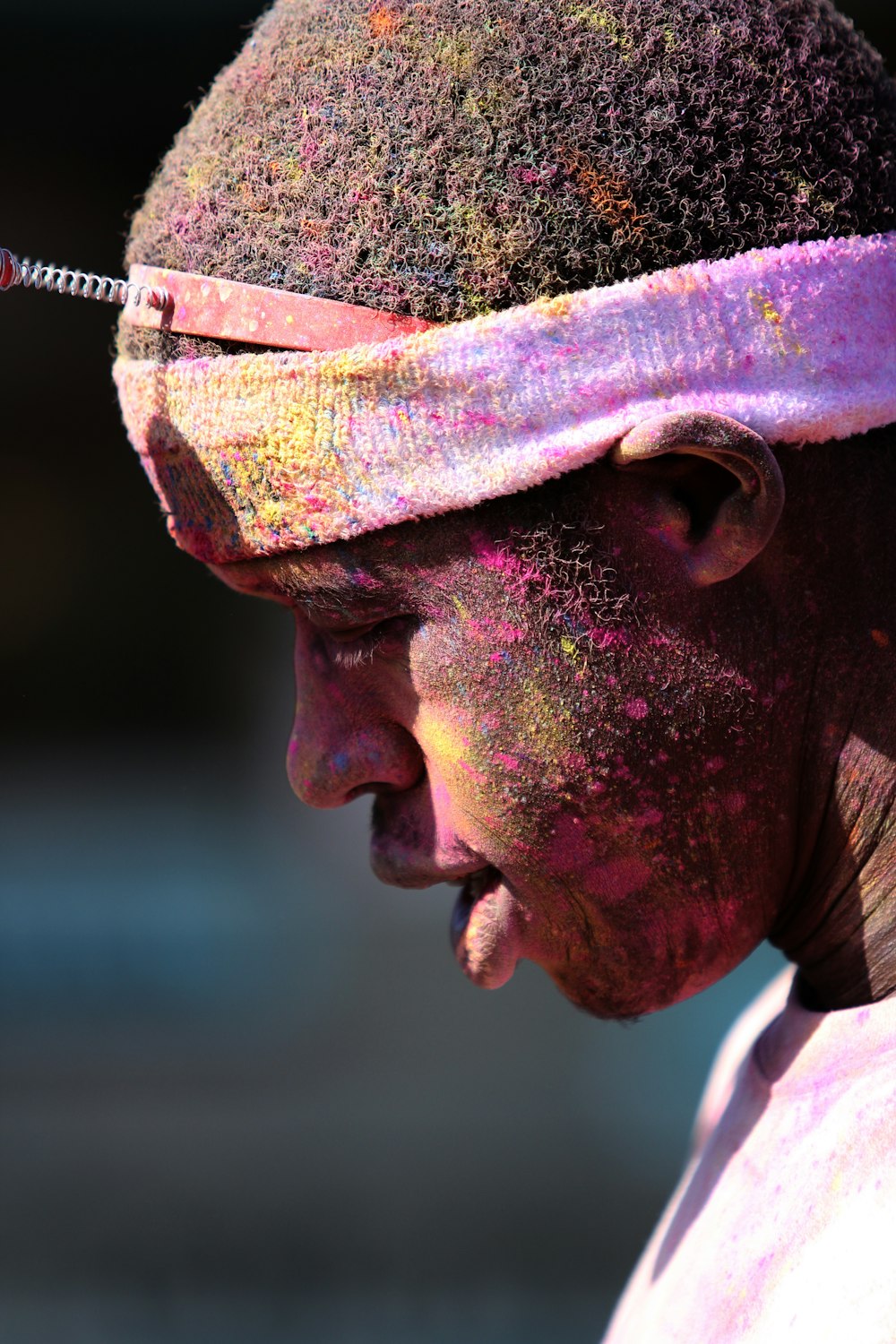 man with pink paint splattered hair and face