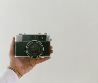 person holding grey and black camera