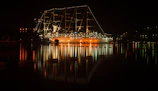 Nighttime view of the cruise ship illuminated with stylish golden lights on the ocean.