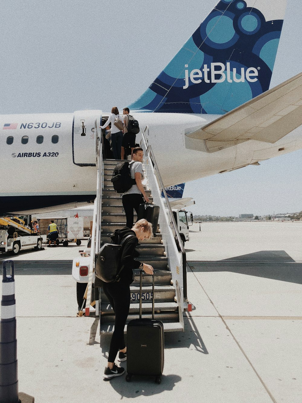 people walking on plane stair during daytime