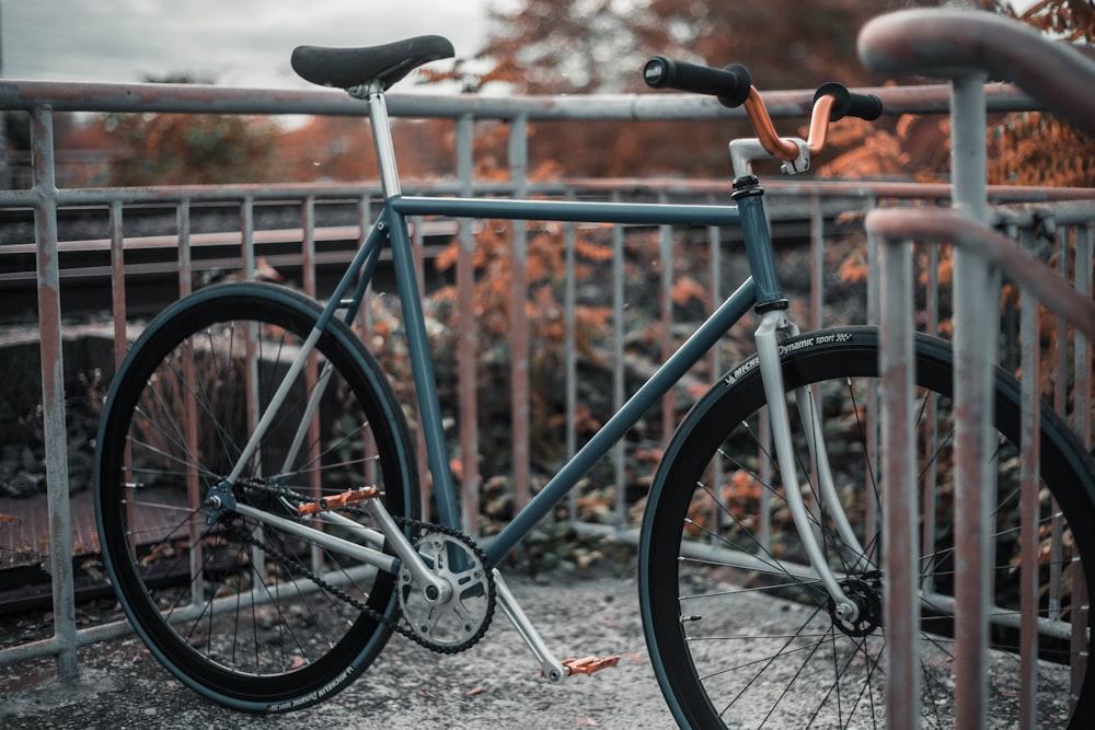 灰色と茶色の金属製の手すりの近くに駐車された灰色の通勤用自転車
