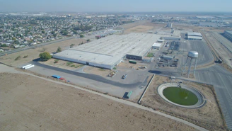 Aerial view of a large, organized fertilizer storage facility with trucks loading products.