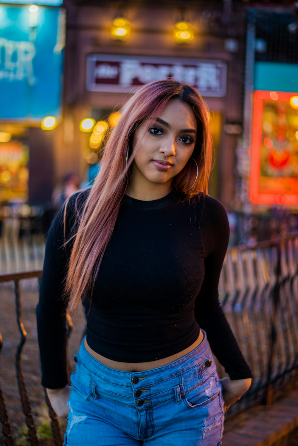 woman in black long-sleeved top standing beside fence