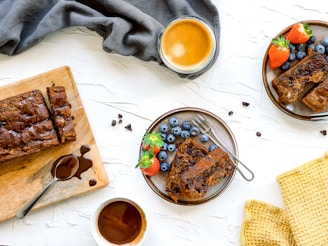 A slice of chocolate chip banana bread resting on a vibrant tropical plate with a backdrop of palm leaves.
