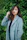 woman in gray coat standing near green plants