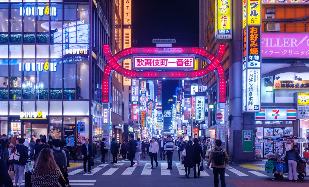 Gente caminando por la calle cerca de los edificios por la noche