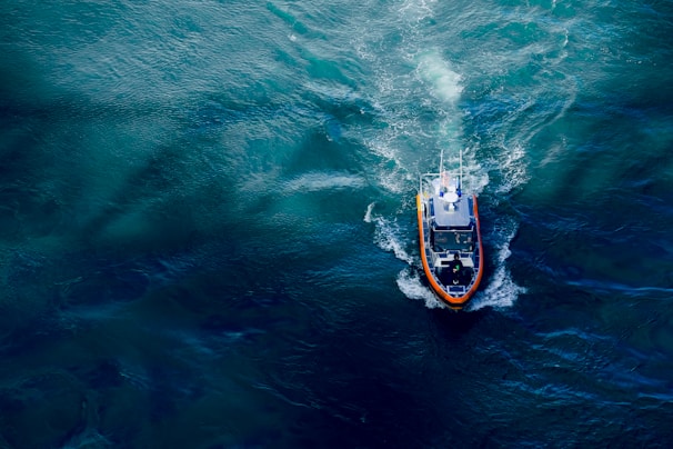A sleek underwater thruster propelling a small submersible through clear blue water.
