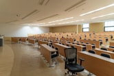 black swivel chair beside rectangular brown wooden desk