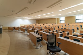 black swivel chair beside rectangular brown wooden desk
