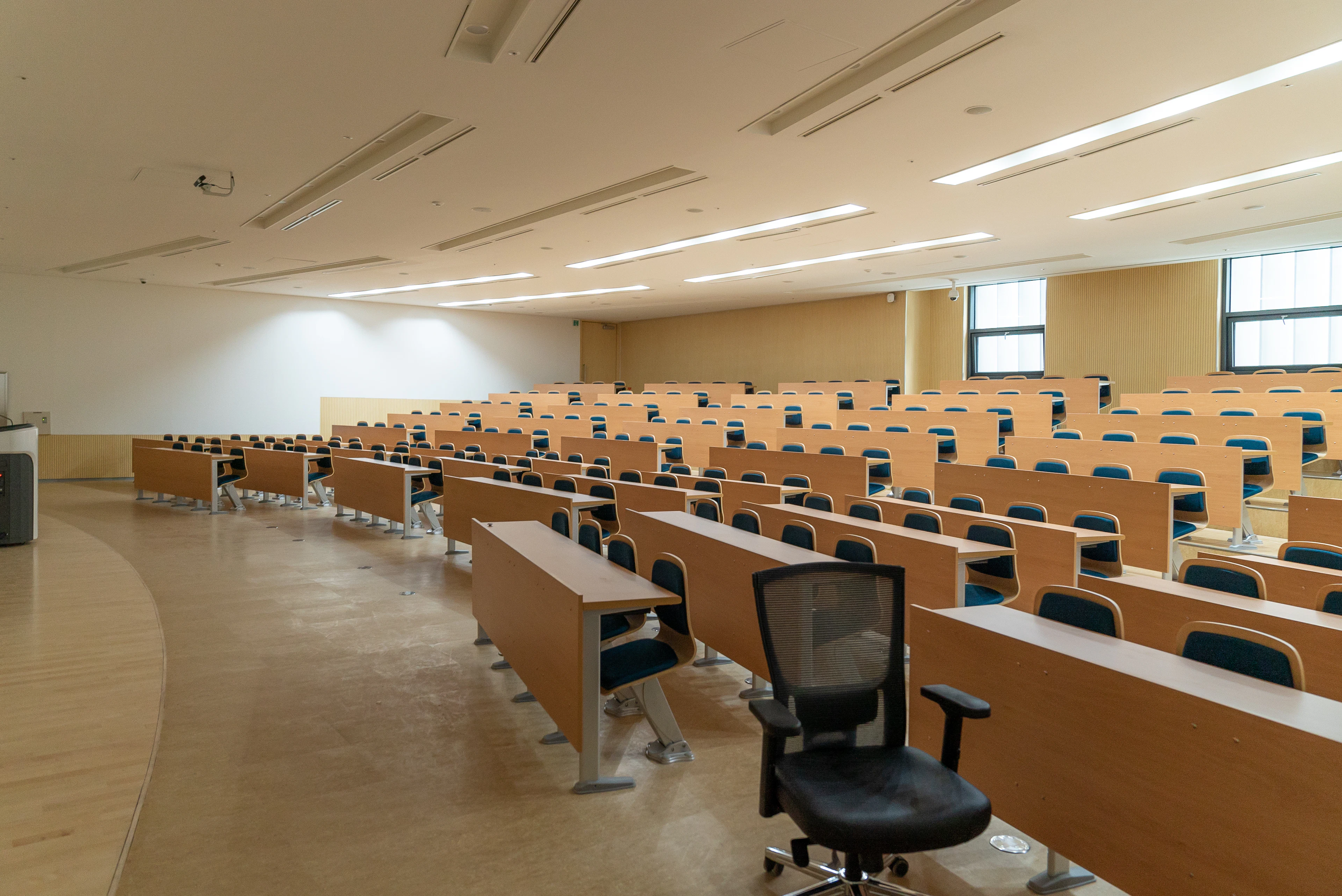 Anfiteatro universitário vazio com carteiras de madeira