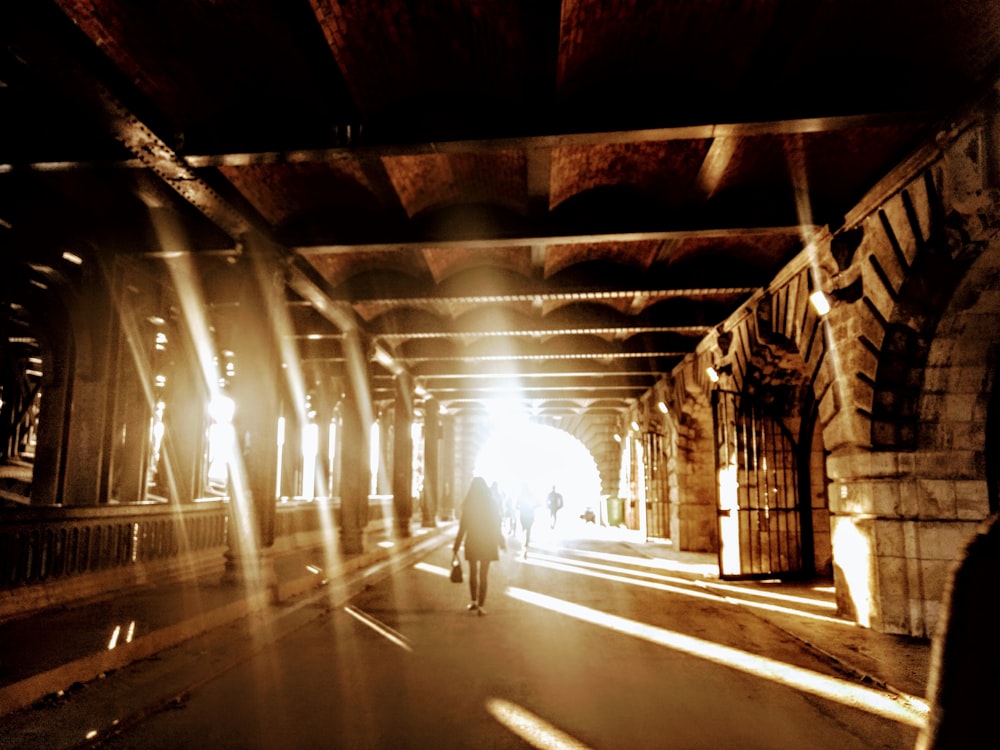 person walking in tunnel during daytime