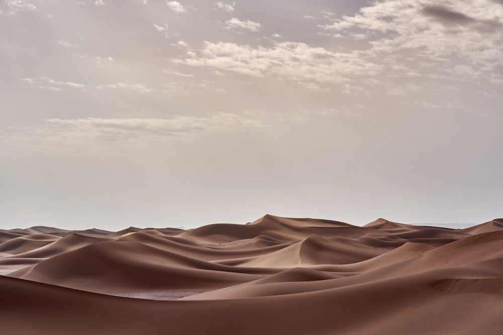 Deserto marrom sob nuvens brancas