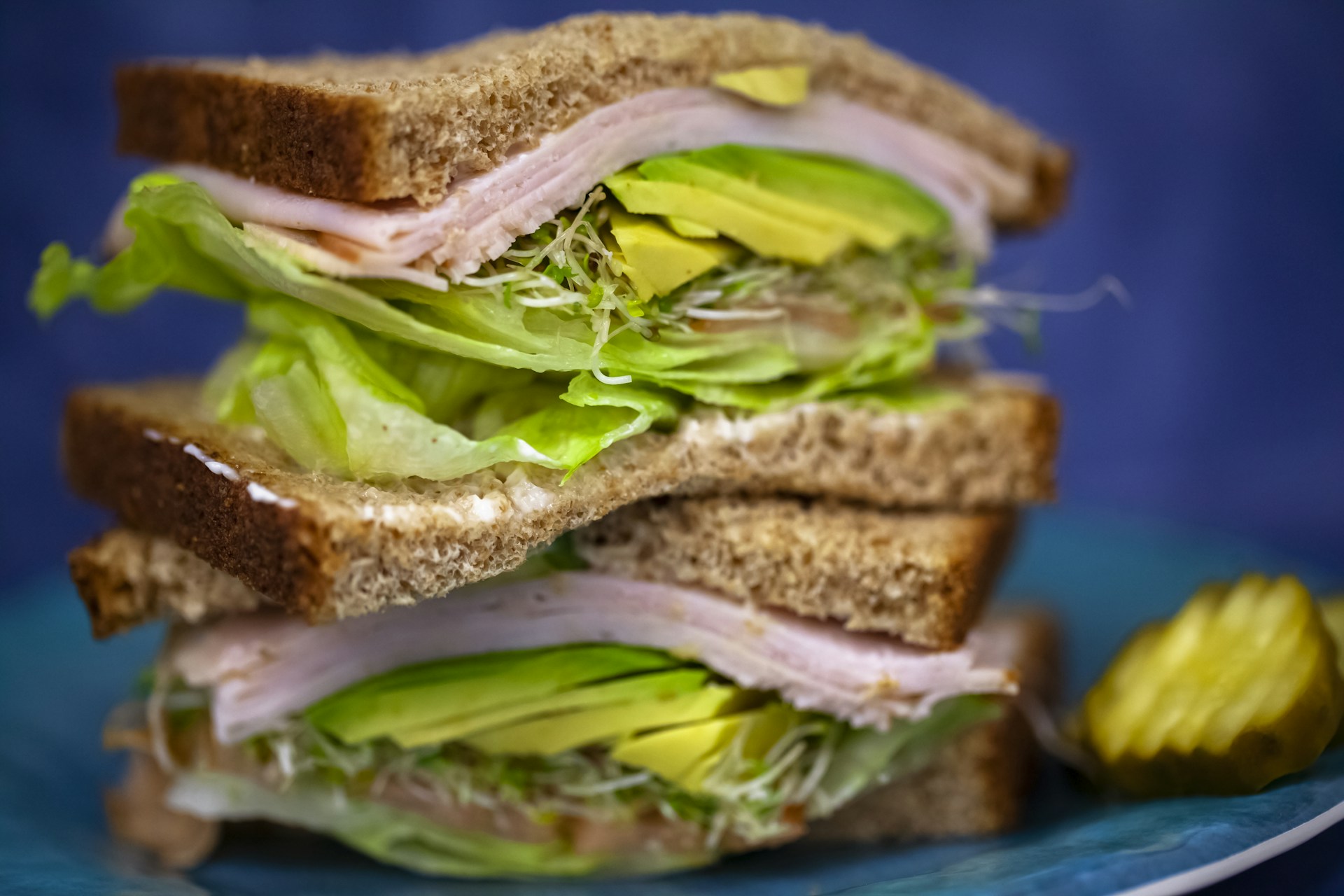 A vibrant natural sandwich featuring avocado, sprouts, and turkey slices, priced at 12 reais.