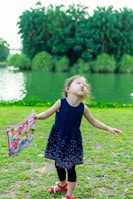 A cheerful child wearing a handmade dress with traditional Lithuanian colors, playing outdoors.