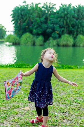 A cheerful child wearing a handmade dress with traditional Lithuanian colors, playing outdoors.