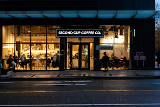 A warm, inviting coffee shop interior with people chatting and enjoying coffee together.