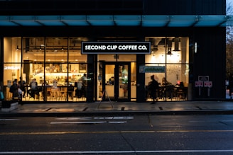 A warm, inviting coffee shop interior with customers enjoying drinks and snacks.