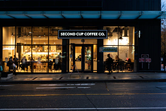 A warm, inviting coffee shop interior with people chatting and enjoying coffee together.