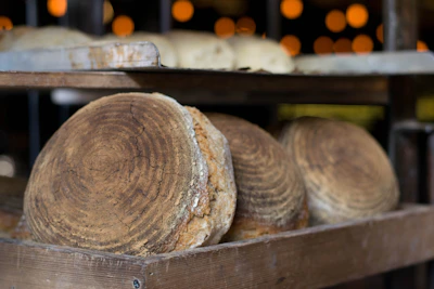 Freshly baked bread loaves cooling on a rustic wooden rack with warm morning light.